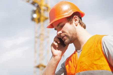 Man builder worker in helmet posing on construction site. Portrait of construction worker outdoor.の写真素材