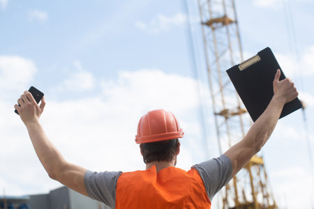 Construction worker in uniform and safety equipment have job on building.