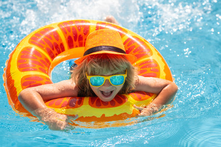 Boy kid swimming and playing in a pool. Child playing in swim pool. Summer fashion kids portrait....