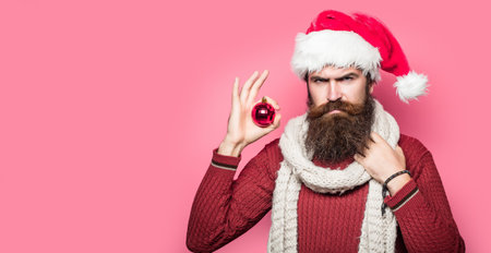 Bearded santa man, christmas card, new year banner with copy space. Funny santa isolated over red studio background.の写真素材