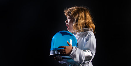 Close-up face of little astronaut with helmet looking dreamily. Isolated background with copy space....