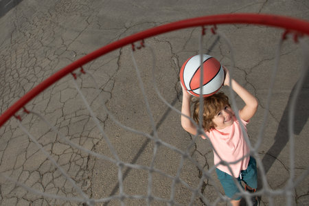 Little child boy playing basketball with basket ball. View of flying ball to basket from top, kid play basketball.の写真素材