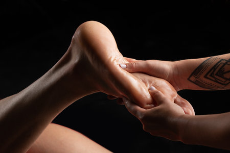 Close up of foot massage. Professional foot massage close up. Authentic shot of luxury spa treatment. Isolated on black.の写真素材