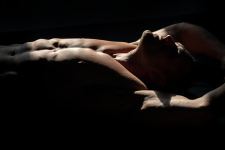 Mans powerful shoulders. Muscular shirtless manked man model showing six pack abs. Gay sexy model. Muscular sexy man with naked torso. Hunk with athletic body.の写真素材