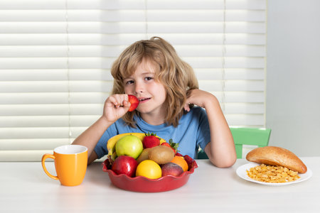 Child eats strawberry, organic fruits. Healthy vegetables with vitamins. Proper kids nutrition concept.の写真素材