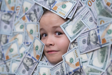 American dreams. Head in money. Fun kid face on dollars money.の写真素材