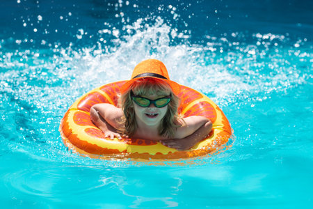 Child in pool in summer day. Children playing in swimming pool. Kids holidays and vacation concept.の写真素材