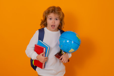 School and education kids concept. Clever school boy with school supplies on yellow studio...