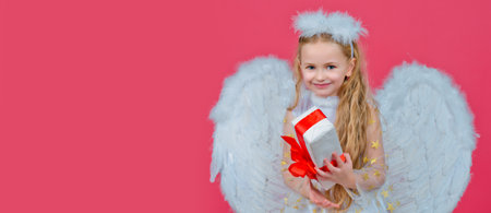 Angel kid banner, isolated studio background. Gift child emotions. Cute angel child girl with angels wings, isolated on red. Valentines day. Playful angelic little girl.の写真素材
