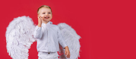 Valentines day banner with angel child. Portrait of a beautiful happy boy with angel wings. Horizontal banner for website header, copy space.の写真素材