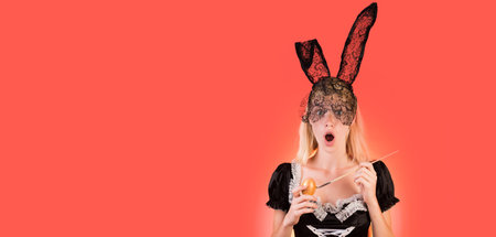 Happy young woman wearing bunny ears and having Easter Eggs copy space. Crazy people. Woman easter. Beautiful sensual blonde. Easter banner, mockup copy space, poster header for website template.の写真素材