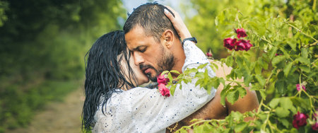 Couple in love, spring banner. Love in the garden. Passionate couple in the garden hugging.の写真素材