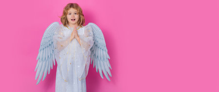 Angel prayer kids. Little cupid angel child with wings. Banner header, copy space. Studio portrait of angelic kid.の写真素材
