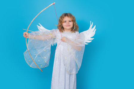 Angel kid shoots a love arrow from a bow on Valentines Day. Portrait of cute kid with angel wings...
