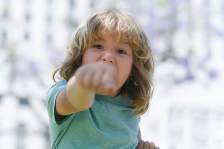 Boy fight with fist gesture punch. Child with angry expression. Angry hateful little crazy boy, child furious. Angry rage kids face. Aggressive and mad kid angry behavior.の写真素材