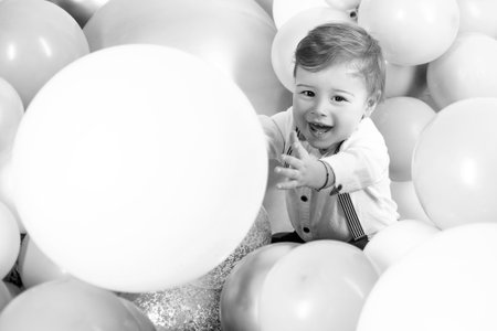 Funny boy. Beautiful smiling child with ballons. Celebrating birstday b-day. Enjoying the moment. Emotions on the face. Adorable baby having fun. Happy moments. Copy space.の写真素材