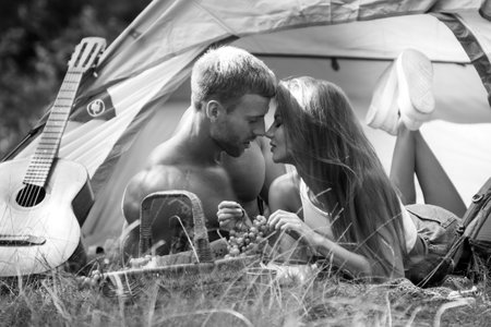 Romantic couple camping on nature background. Adventure for young friends on summer day. Young couple in love hug each other. Sexy couple travel kissing on holidays camp.の写真素材