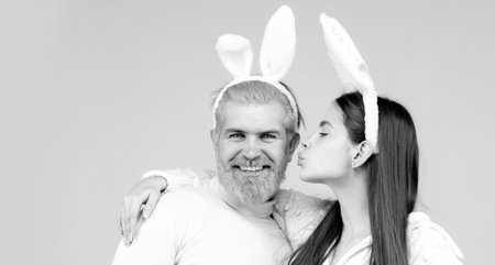 Happy Easter couple kissing, bunny rabbit woman and man hold board paper. Funny Easter bunny couple...