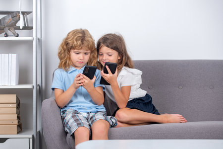 Two kids using online app on mobile phone, making call, watching content, browsing internet, playing...