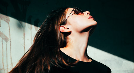 Woman fashion style. Beautiful sexy girl with casual dress walking on the street. Hair movement of sensual brunette woman.の写真素材