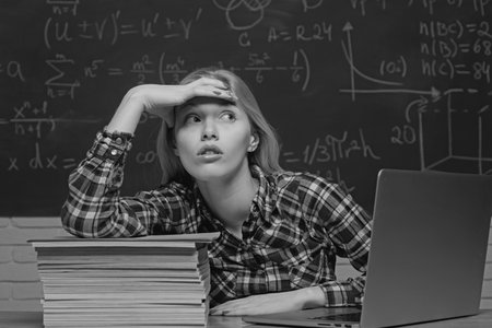 Back to school. Student working on a laptop on some stairs on campus preparing for an exam. Angry screaming - negative emotions.の写真素材
