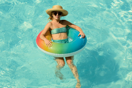 Summer vacation. Woman in swimmingpool. Having fun at aquapark. Swiling girl on inflatable rubber...