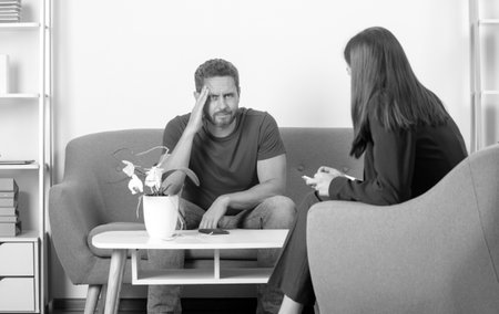 Social worker psychologist talking to man. Depression counseling. Depressed middle aged man problem therapy.の写真素材