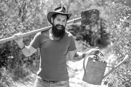 Garden man with tools. Happy Farmer with Shovel and watering can. I love our moments in the countryside. Earth day. Summer farming.の写真素材