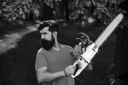 Deforestation. Man doing mans job. Lumberjack worker with chainsaw in the forest.の写真素材