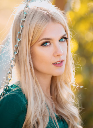 Close up face of young stylish woman. Beautiful thoughtful pensive girl outdoor portrait. Young blonde woman on sunny summer day.の写真素材