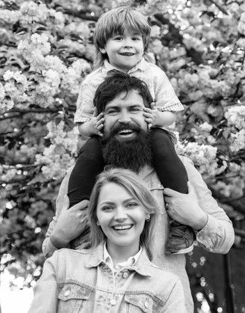 Parents giving piggyback ride to child. Happy family outdoors. Mother father and son. Portrait of...