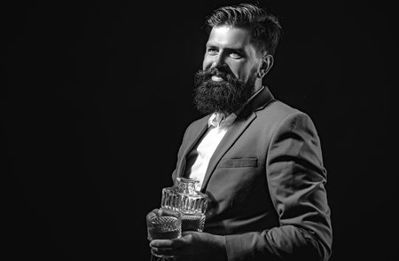 Handsome bearded businessman is drinking expensive whisky.の写真素材