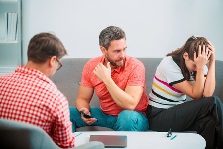 Couple discussing problems in family with social worker or family psychologist. Family conflicts, marital crisis.の写真素材