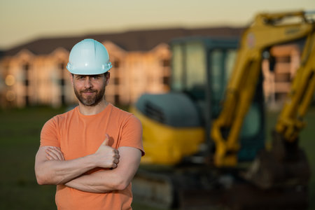 Builder in a construction site. Builder with excavator ready to build new house. Construction...