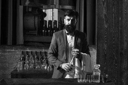 Waiter bartender in bar. Portrait of cheerful barman worker standing.の写真素材