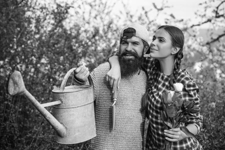 Lifestyle and family life. Two people gardening in the backyard garden. Happy Couple Farmers working with spud on spring field.の写真素材