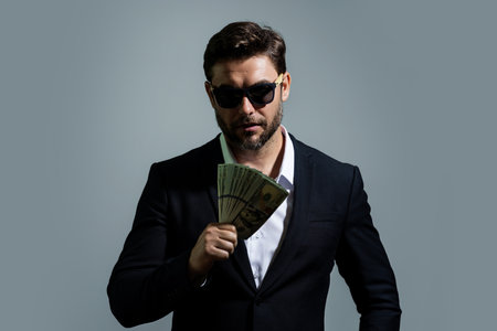 Business man in t-shirt with cash money dollars banknotes isolated on yellow studio background....