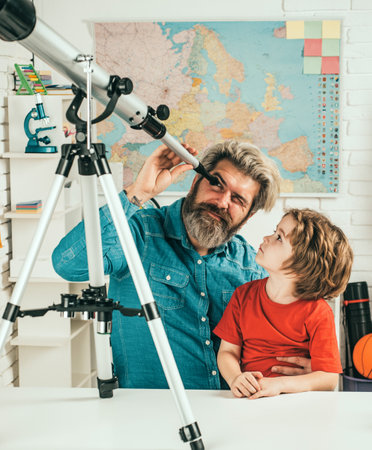 Father teaching son. Pupil watching stars with a teacher. Astronomy telescope.の写真素材