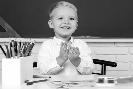 Happy school kids at lesson. Individual tutoring. School kids against green chalkboard. Schoolkid or...