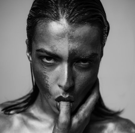 Oral sex pleasure. Golden skin. Sexy girl face makeup metallized color. Richness and wellbeing. Luxury beauty procedure. Golden lady relaxing. Golden girl suck finger. Vogue and glamour conceptの写真素材
