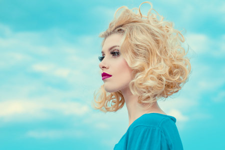 Close-up portrait of sexy caucasian young woman with beautiful blue eyes. On sky background.の写真素材