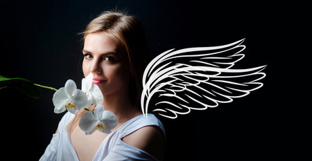 Valentines day horizontal photo banner for website header design. Angel beauty woman with wings. Sensual girl with orchid flower. Woman and orchids on black. Portrait of cute female face.の写真素材