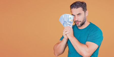 Man hold money on beige studio isolated banner background. Rich man in suit with money dollar bills....