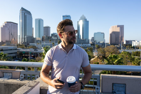 Urban style guy with casual clothes walk in Tampa city. Portrait of attractive man with casual clothes walk in American city. Handsome young man in an urban fashion lifestyle walking in the street.の写真素材