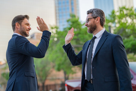 Business man shaking hands, high five sign. Two businessmen handshake outdoor. Handshake business people. High five hand of business man in suit outdoor.の写真素材