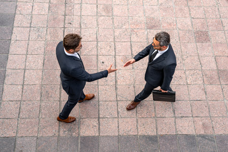 Business man shaking hands. Two businessmen handshake outdoor. Handshake business people. Businessmen communicating at meeting. Handshake of two business man in suit top view.の写真素材