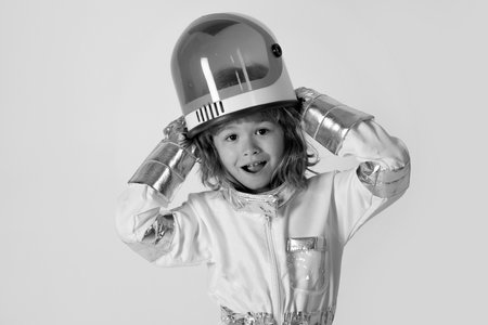 Close-up face of little astronaut with helmet looking dreamily. Little boy in space suit smiling at camera. Cute little boy astronaut.の写真素材