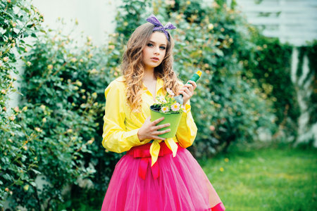 Cute happy teen girl 16 years old with flowers in a pot, home garden. Spring and summer. Teenager girl in summer garden, backyard or farmland. Woman planting flowers in pot.の写真素材