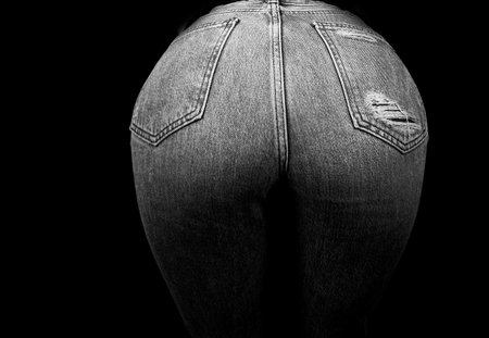 Woman wearing jean pants from back. Female bottom in jeans. Ass girl dressed in jeans. Very sexy ass. XXL. Black background isolated,の写真素材