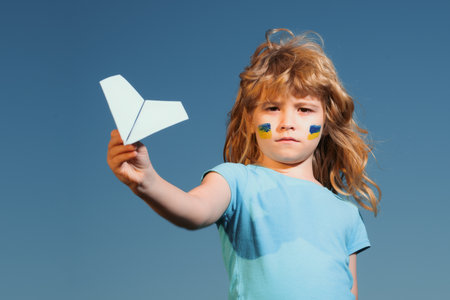 Close the sky over Ukraine banner. No fly zone over Ukraine. Ukraine flag on kids cheek.の写真素材
